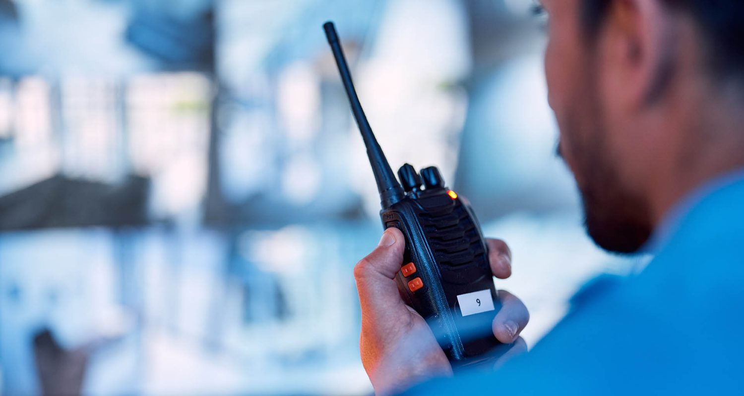 Security guard, radio and cctv monitor, communication and inspection service for building safety. Screen, video surveillance agency and law officer in control room talking on two way intercom system.; Shutterstock ID 2327819167; purchase_order: -; job: -; client: -; other: -